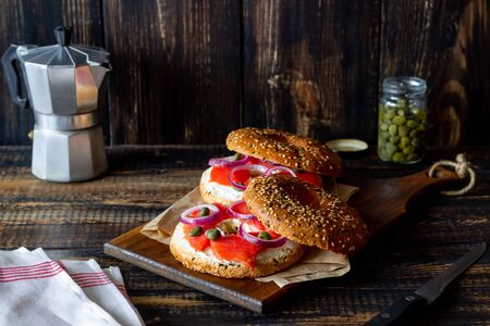 Bagels with salmon, white cream cheese and capers on a wooden background. Recipes. Healthy eating. Breakfast.の写真素材