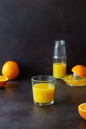 Freshly squeezed orange juice on a dark background. Healthy eating. Diet. Vegetarian food
