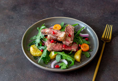 Grilled beef steak salad with arugula, potatoes, carrots, onions and pomegranate. Healthy eating. Dietの写真素材