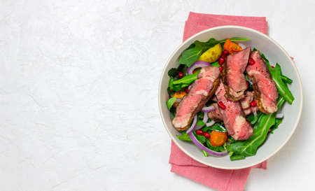 Grilled beef steak salad with arugula, potatoes, carrots, onions and pomegranate. Healthy eating. Dietの写真素材