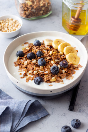 Granola with yogurt, blueberries, nuts, banana and honey. Muesli. Healthy eating. Vegetable food
