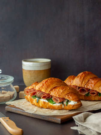 Croissants sandwiches with prosciutto, basil and white cheese. French cuisine. Breakfastの写真素材