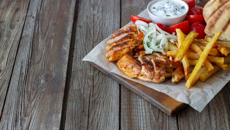 Greek dish gyros with chicken, french fries, tomatoes, onions and pita. Greek cuisineの写真素材