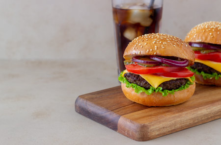 Burgers with cutlet, tomato, lettuce, cucumber, onion and cheese. American cuisine Fast food Cheeseburger