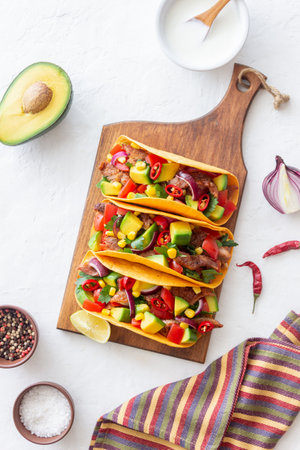 Tacos with pork, avocado, tomatoes, corn and onions. Mexican foodの写真素材