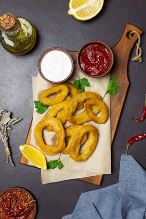Fried squid rings with two sauces, lemon and herbs. fast food. Appetizer