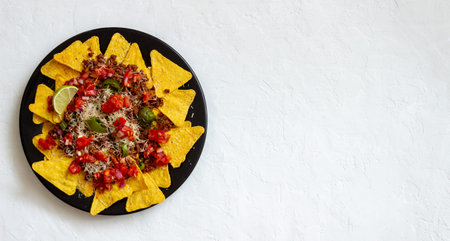Corn chips nachos with meat, cheese, tomatoes and peppers. Mexican food. National cuisine