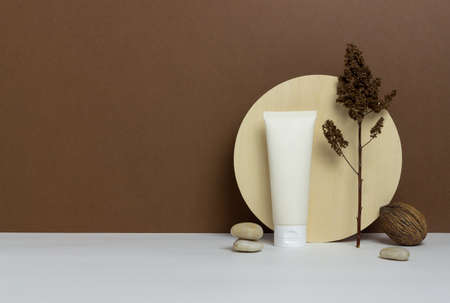 Cosmetic cream in a tube on a brown background. Natural cosmetics. Skincare. Mock-up. Copy spaceの写真素材