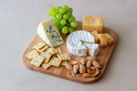 Cheese plate with cracker, almonds and grapes. Wine appetizer. Wine snack