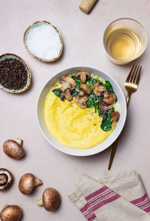 Polenta with mushrooms, spinach and cheese. healthy eating. Vegetarian food. Italian foodの写真素材