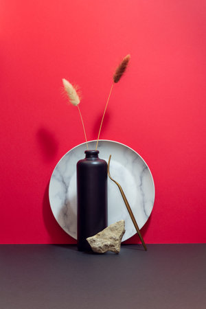 Still life with plate, vase, flowers and stone. Design Minimalism