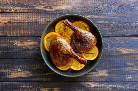 Baked duck legs with oranges and rosemary. rustic styleの写真素材