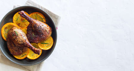 Baked duck legs with oranges and rosemary. rustic styleの写真素材