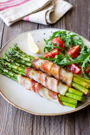Asparagus baked with bacon and arugula and tomato salad. healthy eating. Dietの写真素材