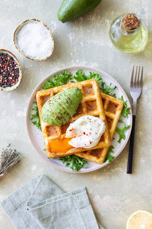 Belgian waffles with avocado and poached egg. Healthy eating. Vegetarian food. Breakfastの写真素材