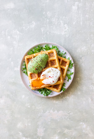 Belgian waffles with avocado and poached egg. Healthy eating. Vegetarian food. Breakfastの写真素材