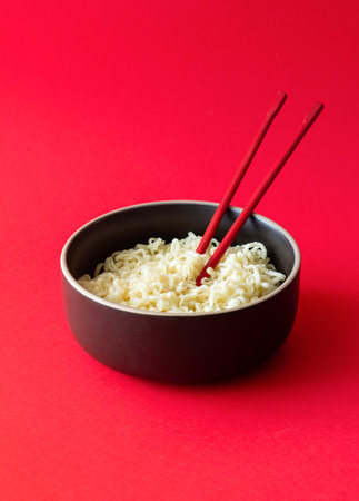 Instant noodles on red background. Vegetarian food. Asian cuisine.の写真素材