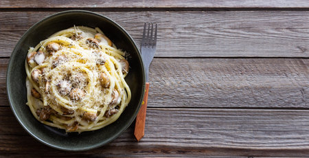Bucatini pasta in creamy sauce with mushrooms and cheese. Vegetarian food. Italian cuisineの写真素材