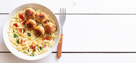 Orzo pasta with chicken meatballs, tomatoes and herbs. Italian food
