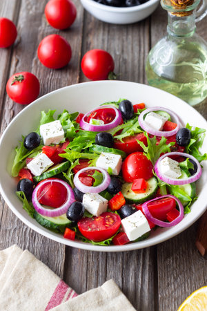 Greek salad with feta cheese, tomatoes, onion, cucumbers, peppers and olives. Healthy eating. Vegetarian foodの写真素材