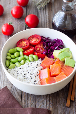 Poke bowl with rice, salmon, avocado, red cabbage, edamame and tomatoes. Healthy food. Diet