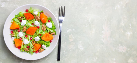 Salad with persimmon, feta cheese, pomegranate and nuts. Healthy eating. Vegetarianの写真素材