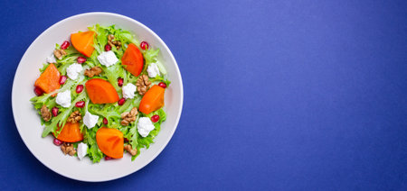 Salad with persimmon, feta cheese, pomegranate and nuts. Healthy eating. Vegetarianの写真素材