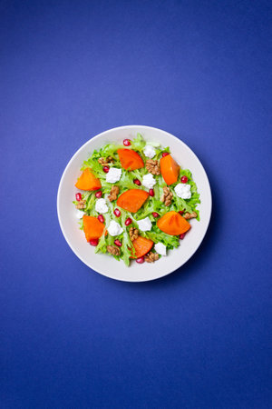 Salad with persimmon, feta cheese, pomegranate and nuts. Healthy eating. Vegetarianの写真素材