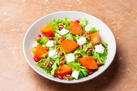 Salad with persimmon, feta cheese, pomegranate and nuts. Healthy eating. Vegetarianの写真素材