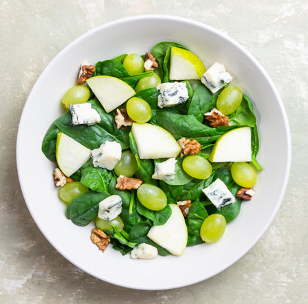Salad with spinach, blue cheese, pear, grapes, and nuts. Healthy eating. Vegetarian.の写真素材