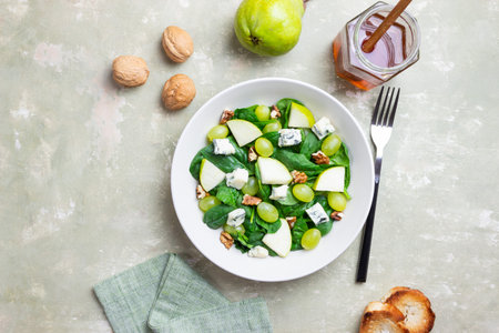 Salad with spinach, blue cheese, pear, grapes, and nuts. Healthy eating. Vegetarian.の写真素材