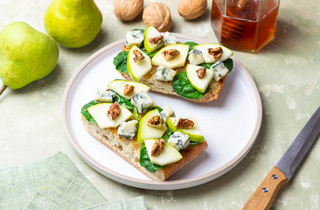 Bruschetta with spinach, honey, blue cheese, pear, and nuts. Healthy eating. Vegetarian foodの写真素材