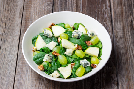Salad with spinach, blue cheese, pear, grapes, and nuts. Healthy eating. Vegetarian.の写真素材