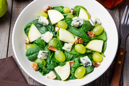Salad with spinach, blue cheese, pear, grapes, and nuts. Healthy eating. Vegetarian.の写真素材