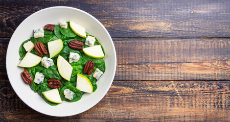 Salad with spinach, blue cheese, pear, and nuts. Healthy eating. Vegetarian food.の写真素材