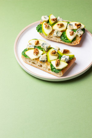 Bruschetta with spinach, honey, blue cheese, pear, and nuts. Healthy eating. Vegetarian foodの写真素材