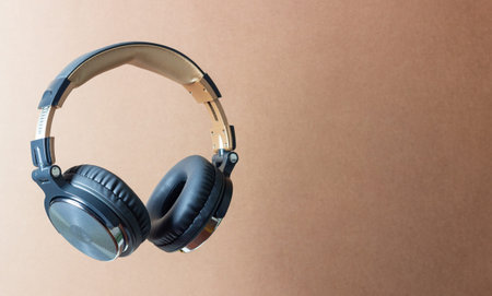 Black headphones on a brown background. Minimal concept. Mock-up. Music. Levitation.