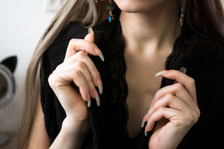 Cropped portrait of young fashion woman model with long natural nails and elegant manicured handsの写真素材
