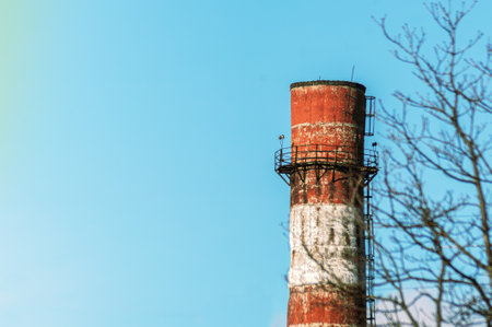 An old cracked red and white pipe from the factory. Industry, ecosystem, nature protectionの写真素材