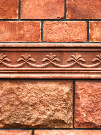 Background of orange retro brick and stone masonry and patterned cornice. Design and architecture conceptの写真素材