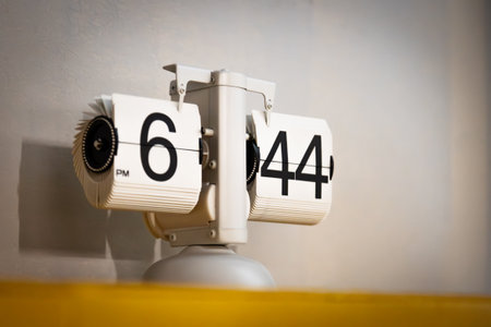 A white flip clock with numerals on a gray background. Time tracking conceptの写真素材