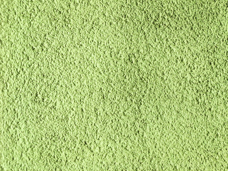 Bright green solid relief texture of an uneven wallの写真素材