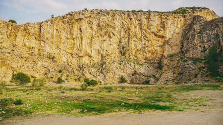 A beautiful and scenic Rocky Cliff adorned with lush green vegetation is truly captivatingの写真素材