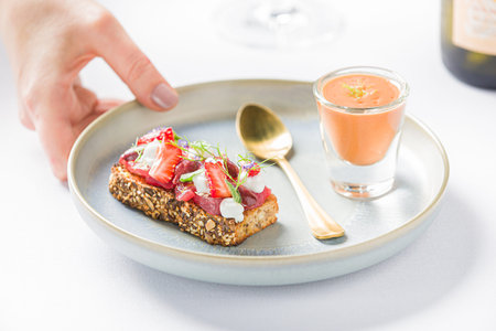 Fresh bruschetta with sliced strawberry, tuna and gazpacho on an appetizer plate, fine dining dish.