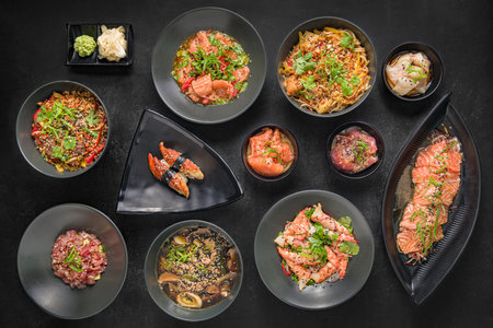 Sashimi set with wasabi, ginger and chopsticks over black stone texture background. top view. Japanese menuの写真素材