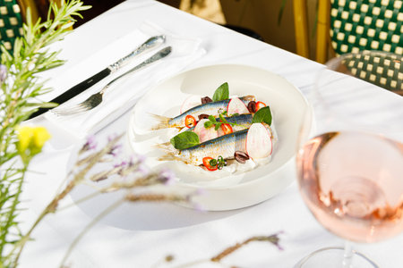 Gourmet Seafood Dinner: Creamy Trout Fillet with Marinated Herring and Fresh Red Onion Salad.の写真素材