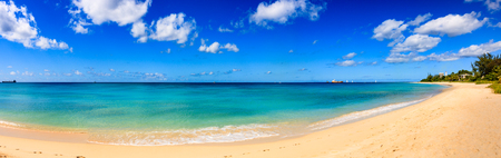 Day at the beach in Barbados Island, Caribbean.  Beach line, white sand, clear turquoise water with small waves and a sunny blue sky.の写真素材