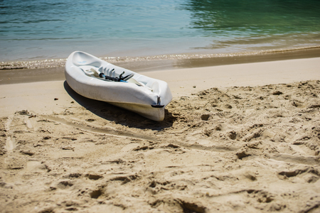 White kayak and paddle by the seashore on the beautiful white sand of Labadee, Haiti.  No people, quiet peaceful sunny day, endless views of the turquoise ocean.の写真素材