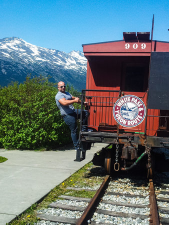 Skagway, Alaska, USA - 2019. Young man getting up in a train cart Yukon Route.のeditorial素材