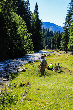 Iezer Mountains - Romania - 2019. People relaxing next to a river, and having barbeque.のeditorial素材